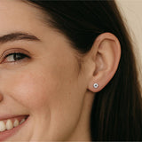 Close-up of a woman wearing a silver stud earring.