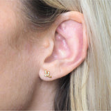 Close-up of an ear with a leaf gold earring