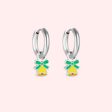 Silver hoop earrings with green and yellow bell charms on a light pink background