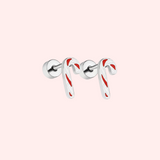 Silver candy cane-shaped earrings with red stripes on a light pink background