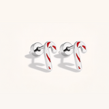 Silver candy cane-shaped earrings with red stripes on a light background