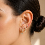 Close-up of model wearing Gold Crystal Cascade Stud Earrings Set of 3 with round cubic zirconia stones in three drop lengths