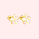 Gold flower-shaped earrings on a light pink background
