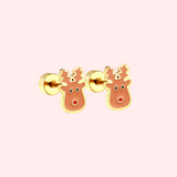 Pair of gold reindeer earrings on a light pink background.