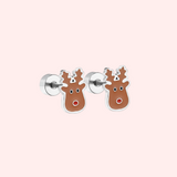 Pair of silver reindeer earrings on a light pink background.