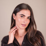 Woman with long brown hair against a beige background