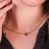 A girl wearing the rudolph sparkle necklace in gold.