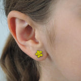 Close-up of a girl wearing a yellow star-shaped earring.