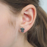 Close-up of a girl wearing a small grey koala-shaped earring.