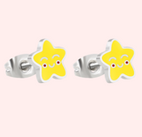 Pair of star-shaped earrings with smiling faces on a pink background