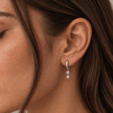 Close-up of model wearing Silver Double Bezel Drop Earrings with two bezel-set clear cubic zirconia stones