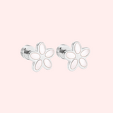 Silver flower-shaped earrings on a light pink background