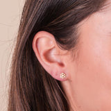 A closeup shot of a girl wearing the gold snowflake stud earrings.