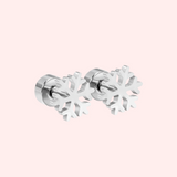 Silver snowflake-shaped earrings on a light pink background