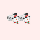 Pair of silver snowman earrings on a light pink background.