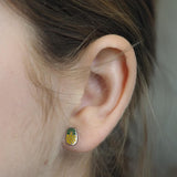 Close-up of a girl wearing a pineapple-shaped stud earring.