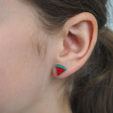 Close-up of a girl wearing a watermelon-shaped stud earring.