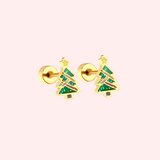 Pair of gold Christmas tree-shaped earrings on a light pink background