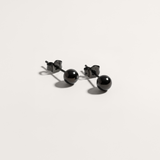 Ball hypoallergenic stud earrings in black on white background