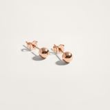 Ball hypoallergenic stud earrings in rose gold finish on white background