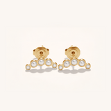 Gold earrings with pearl-like stones on a white background