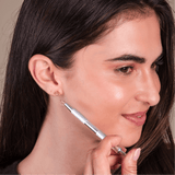 A girl using the earring grabber tool to help with earring application.