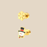 A gold Christmas set with snowflake and snowman earrings on a beige background.