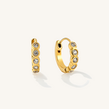 A pair of golden hoops with cubic zirconia bits in the middle.
