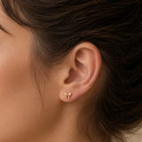 Gold crystal bow flat back earrings worn in the ear, with clear cubic zirconia stones in a delicate bow design.