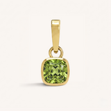 Gold pendant with a green gemstone on a white background