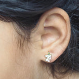 Unicorn earring worn on an ear with a close-up view