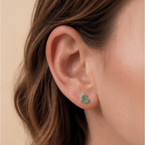 A girl wearing a pair of green heart flat back earrings.