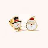 Gold Christmas set with snowman and father Christmas earrings on a beige background.