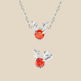 A Christmas set featuring a silver Rudolph charm necklace and earrings on a beige background.