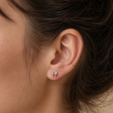 Silver crystal bow flat back earrings worn in the ear, with clear cubic zirconia stones in a delicate bow design.