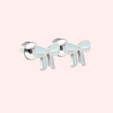 Blue and gold silver bow earring on a light pink background
