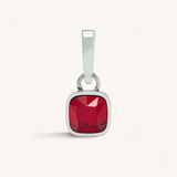 Silver pendant with a red gemstone on a white background
