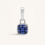 Silver pendant with a blue gemstone on a white background