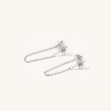 Pair of silver earrings with star designs on a white background