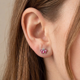 A girl wearing a pair of pink butterfly flat back earrings.