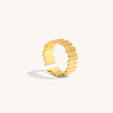 Gold ring with a textured design on a white background.