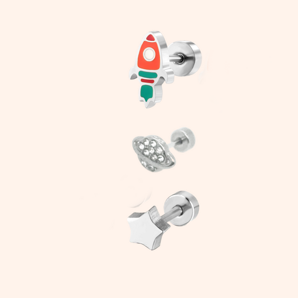 Rocket, planet and Star Silver earring Set on a plain pink background.