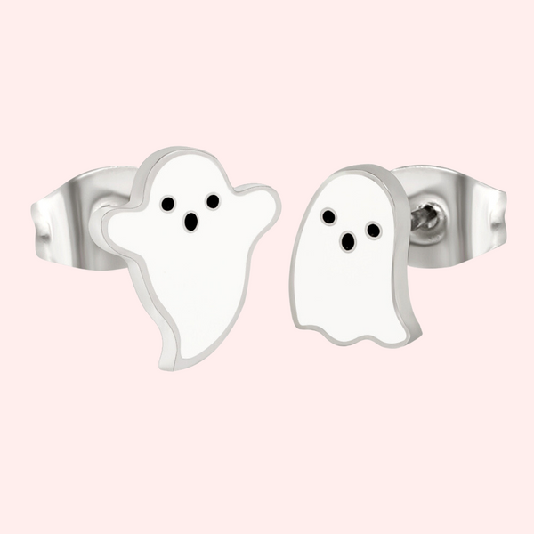 A pair of silver stud earrings designed to resemble ghosts, displayed against a pink background.