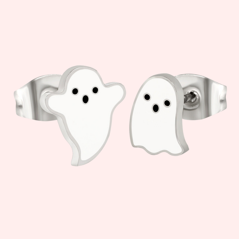 A pair of silver stud earrings designed to resemble ghosts, displayed against a pink background.