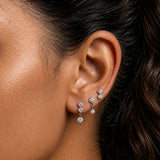 Close-up of model wearing Silver Crystal Cascade Stud Earrings Set of 3 with round cubic zirconia stones in three drop lengths