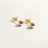Ball hypoallergenic stud earrings in gold on white background
