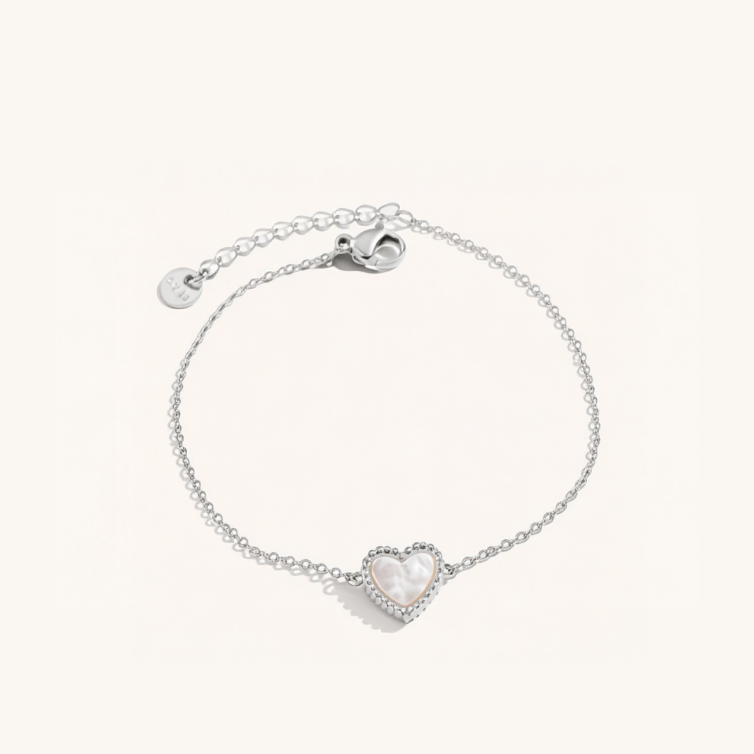 Silver bracelet with a heart-shaped charm on a white background