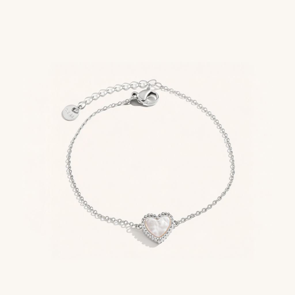 Silver bracelet with a heart-shaped charm on a white background