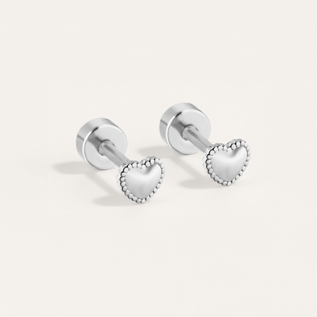 Bead trim heart hypoallergenic flat back stud earring in silver on white background