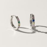 Colourful cubic zirconia hypoallergenic huggie earring in silver on white background
